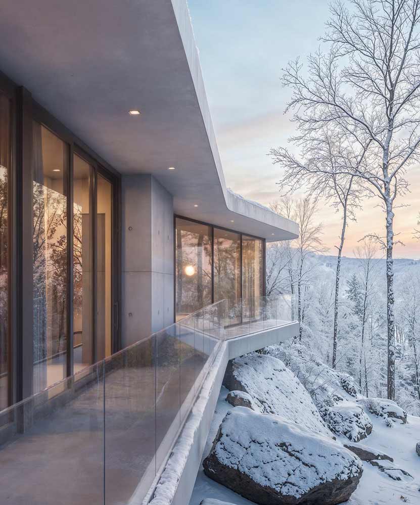 modern concrete and glass home on a steep slope hudson valley architecture snowy winter