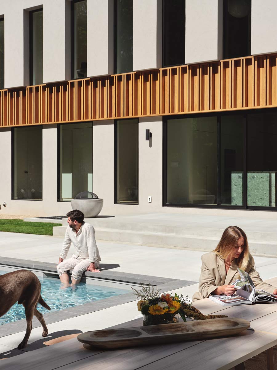 modern outdoor pool seating area beside custom modern architecture