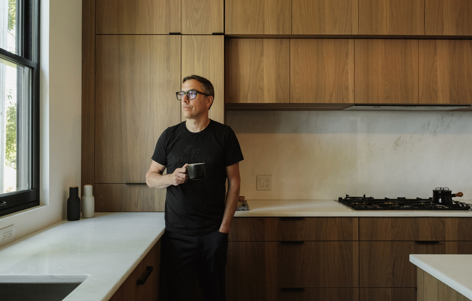 homeowner enjoying coffee in custom walnut modern kitchen interior renovation