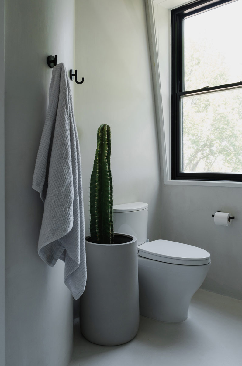 white micro-cement plaster finished minimalist bathroom in victorian home