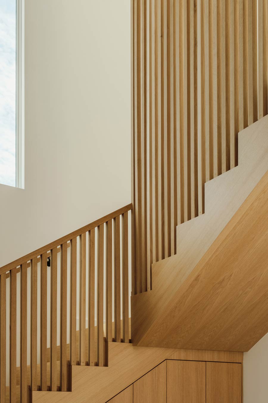 custom light-wood stair in organic modern home with built-in millwork