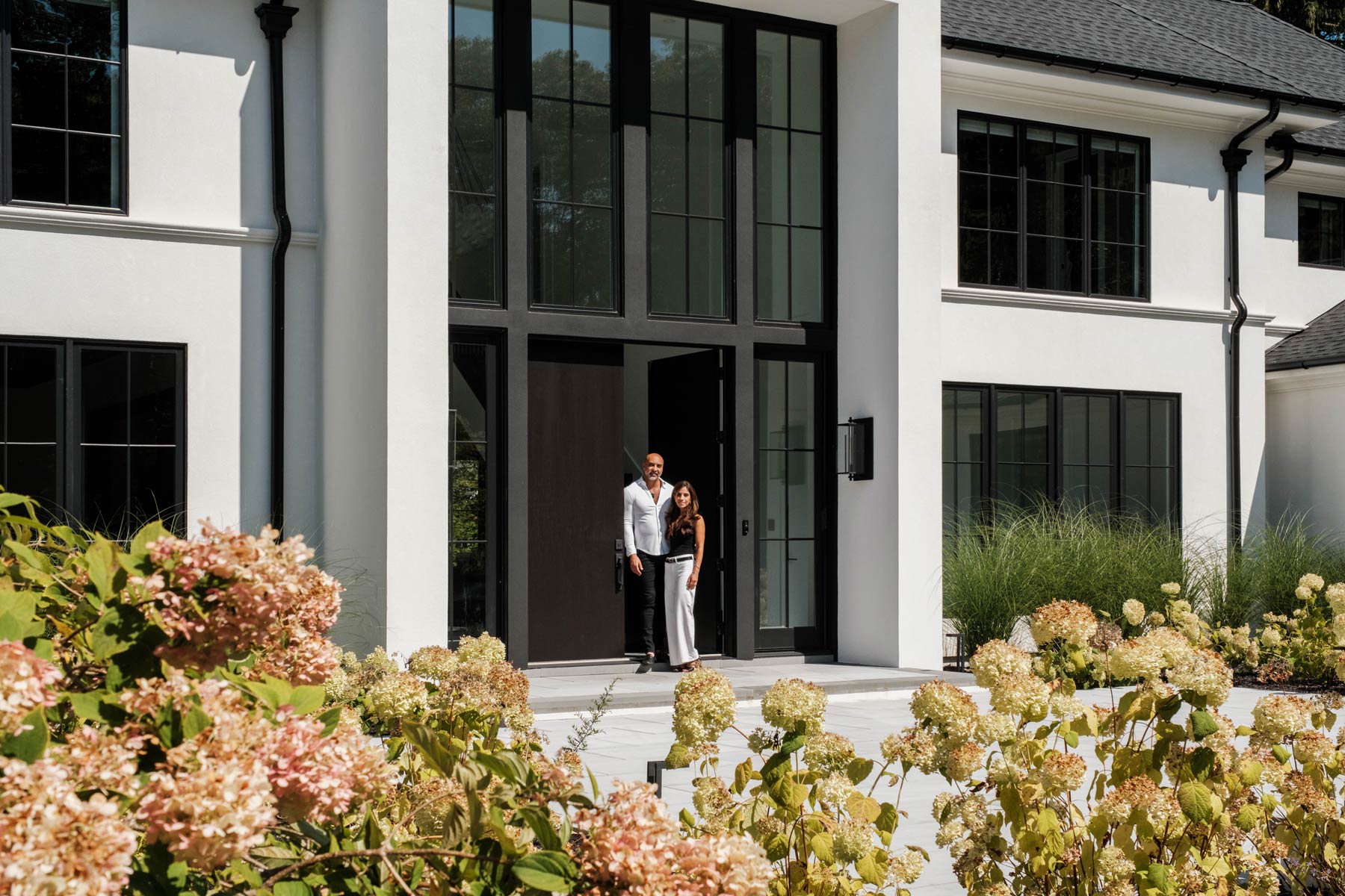 couple at entry to large transitional new york home