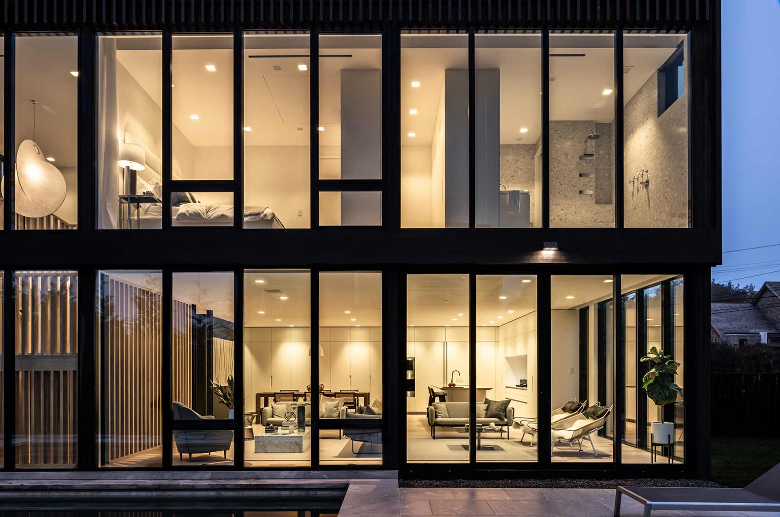 automatic window shades on large window wall in modern home by The Up Studio.