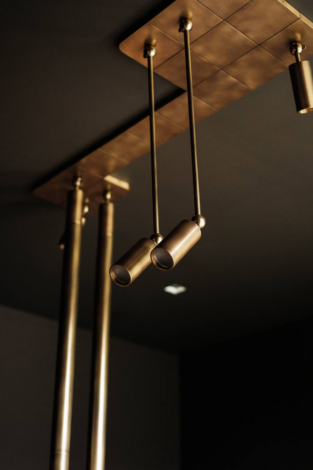 custom brass light fixture by apparatus in moody modern office design