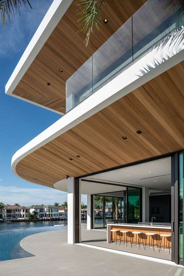 Indoor/outdoor modern kitchen interior architecture in large concrete and cedar home architecture