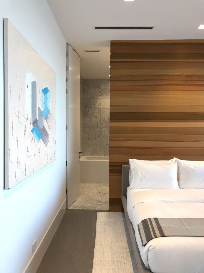 minimal bedroom interior design with cedar wall and white trimless door to modern bathroom