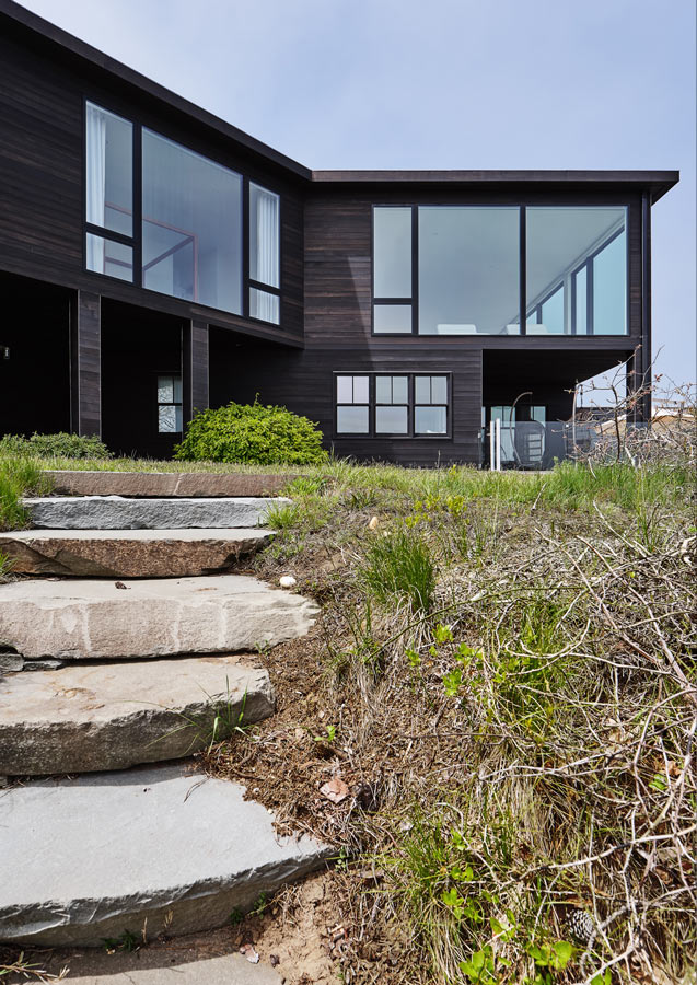 black siding & floor-to-ceiling windows on modern hamptons beach house