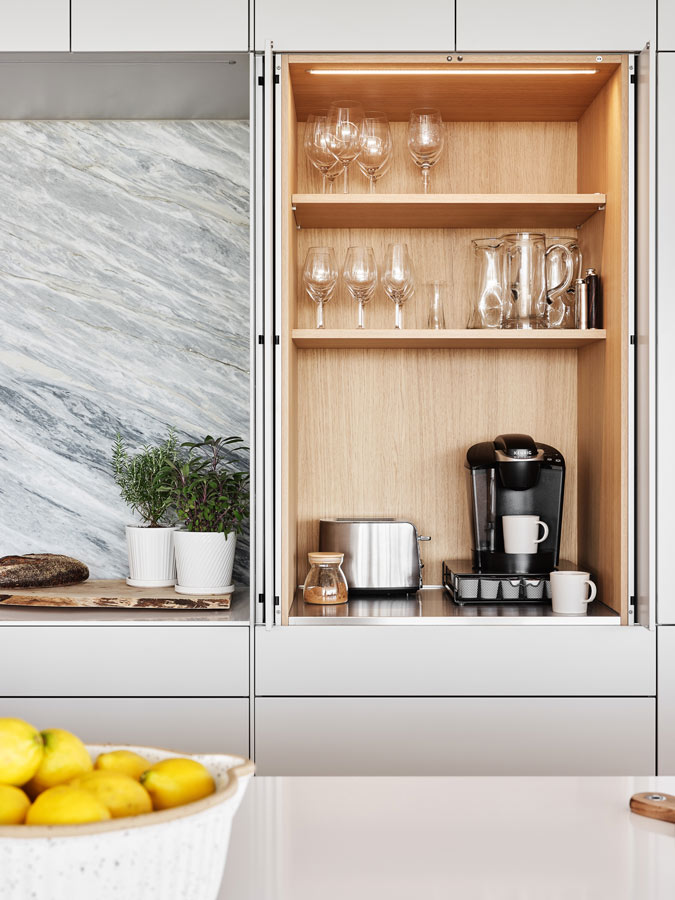 Costs for a modern home with custom hidden pocket door kitchen cabinetry bar by The Up Studio.